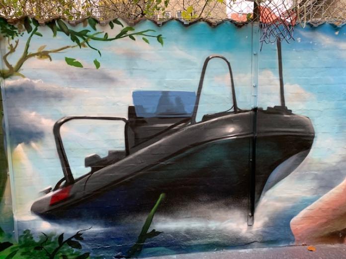 Billede af et vægmaleri hos Brohuset. Maleriet forestiller en speedbåd.